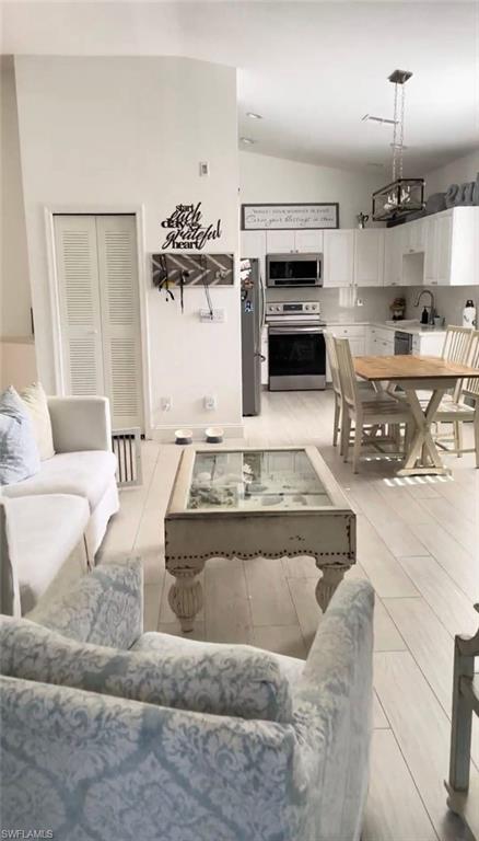 Living area with vaulted ceiling and light tile patterned floors