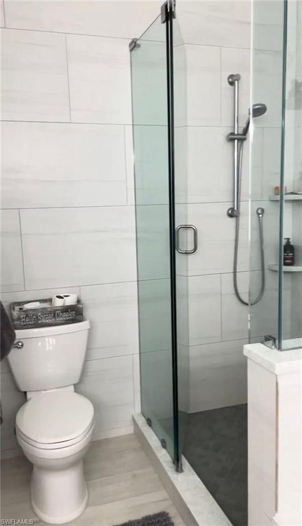 Full bath featuring a stall shower and toilet
