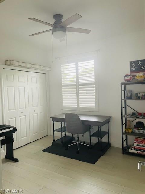 Home office featuring light wood-style flooring and ceiling fan