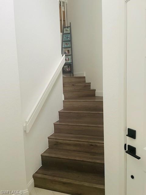 Stairs with baseboards and tile patterned flooring