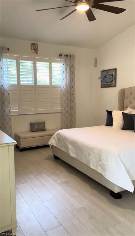 Bedroom with ceiling fan and light wood-style flooring