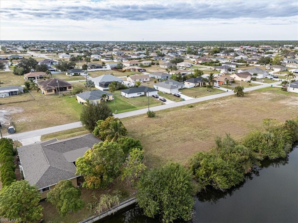Birds eye view of property with a water view