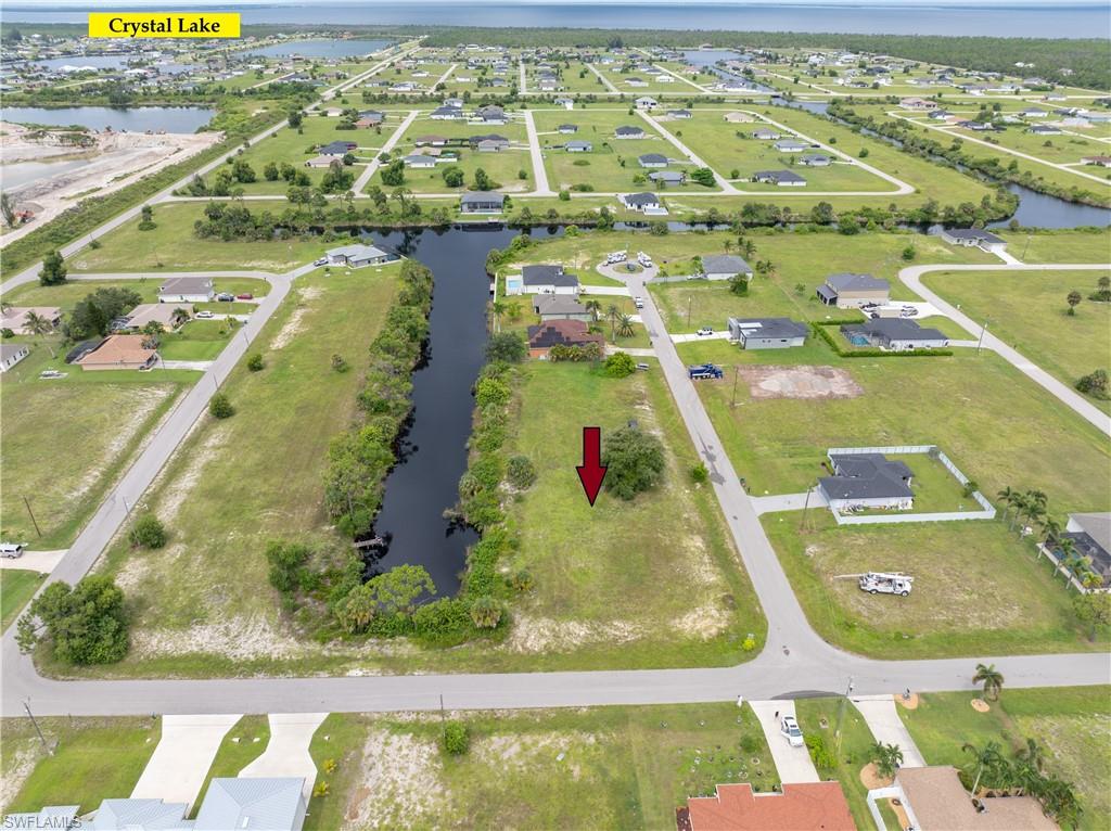 Aerial view of property's location featuring a large body of water and nearby suburban area