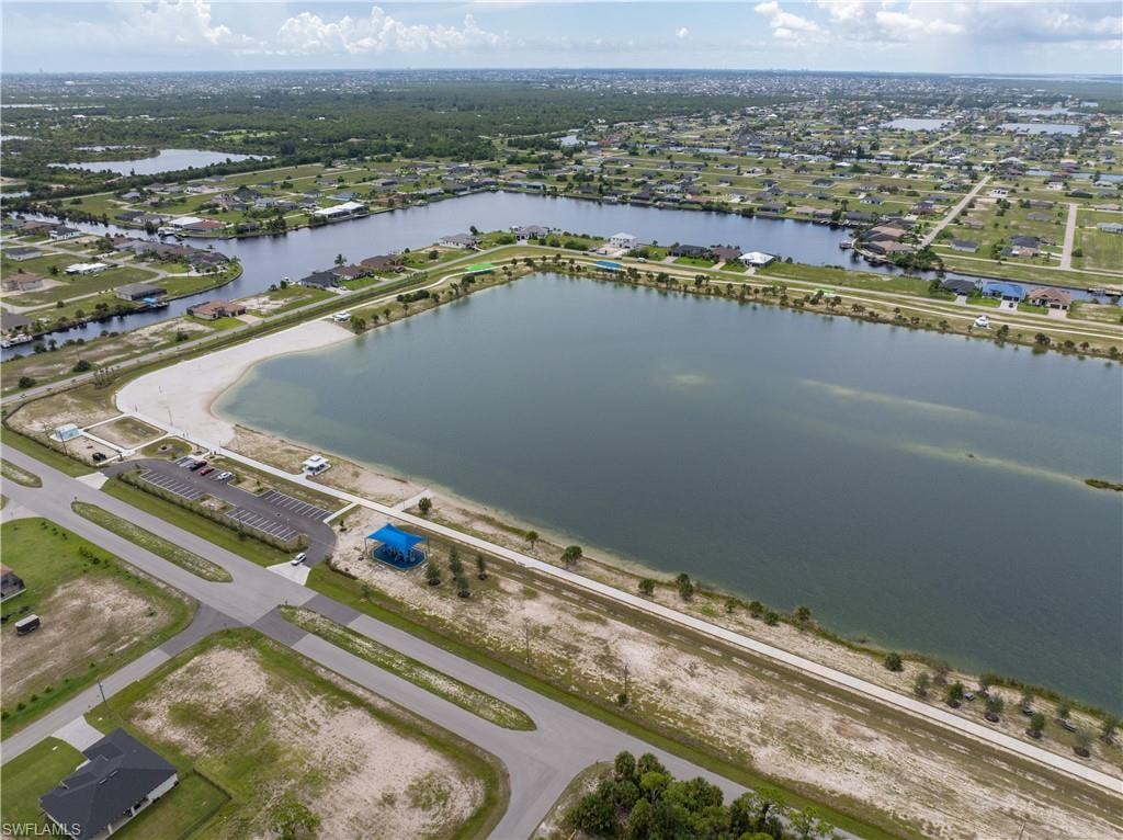 Aerial view of property's location with a nearby body of water and nearby suburban area