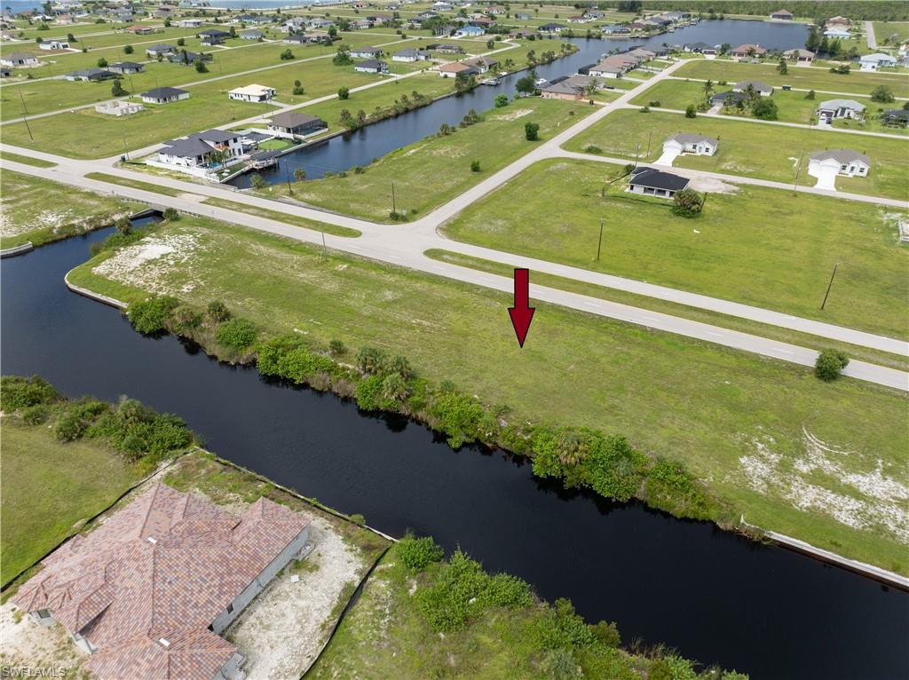 Aerial view of property and surrounding area featuring a large body of water and nearby suburban area