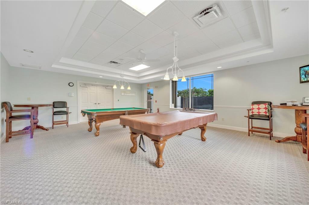 Recreation room featuring a raised ceiling, carpet floors, pool table, and ceiling fan