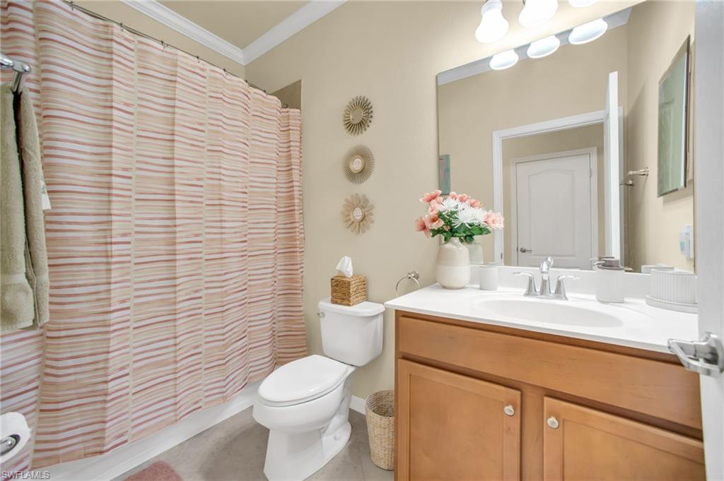 Bathroom with vanity, ornamental molding, and shower / bath combo