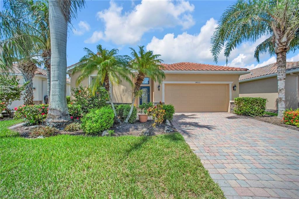 Street view of  house featuring a tiled roof, paver driveway,  and stucco siding