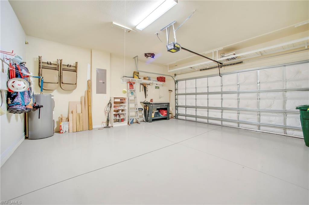 Garage with water heater, electric panel, work bench, loft storage and attic storage