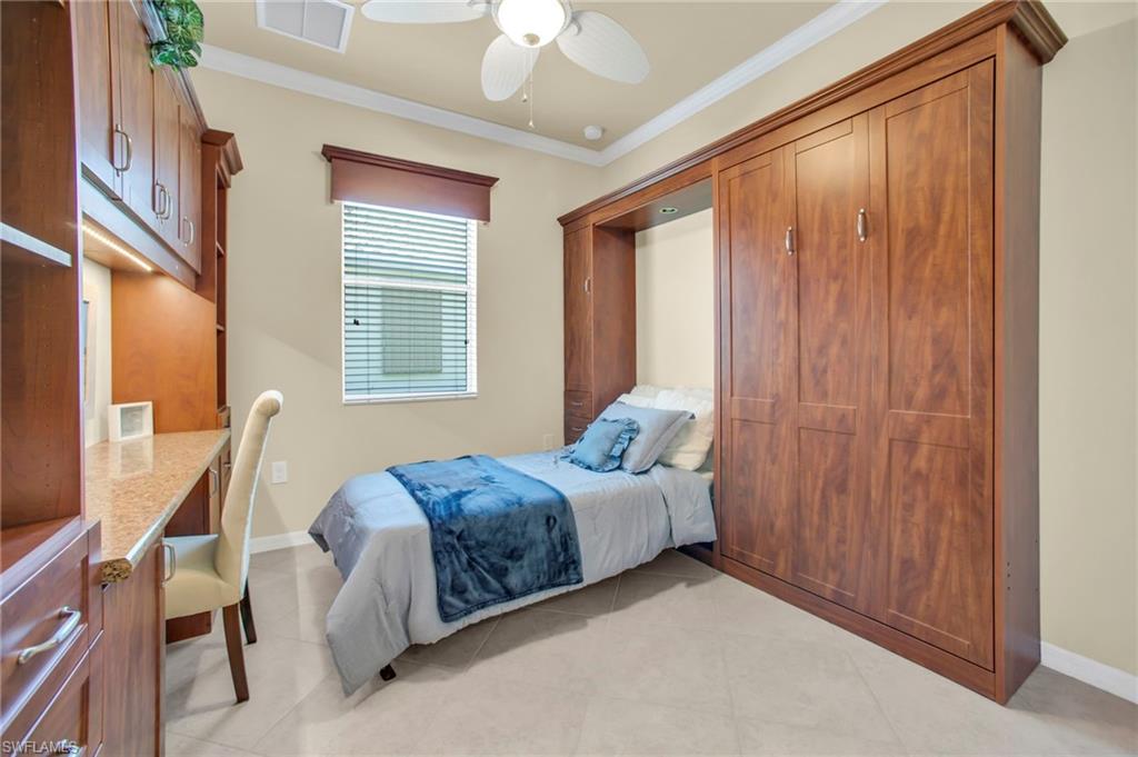 Bedroom with crown molding, ceiling fan, tile , and built in desk and murphy bed system