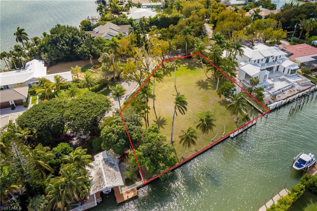 Aerial view of property and surrounding area featuring a large body of water and property parcel outlined