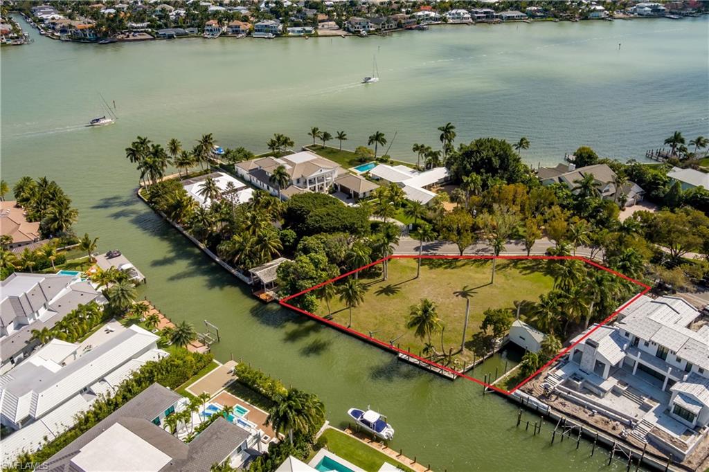 Aerial perspective of suburban area with a nearby body of water and property boundaries highlighted.