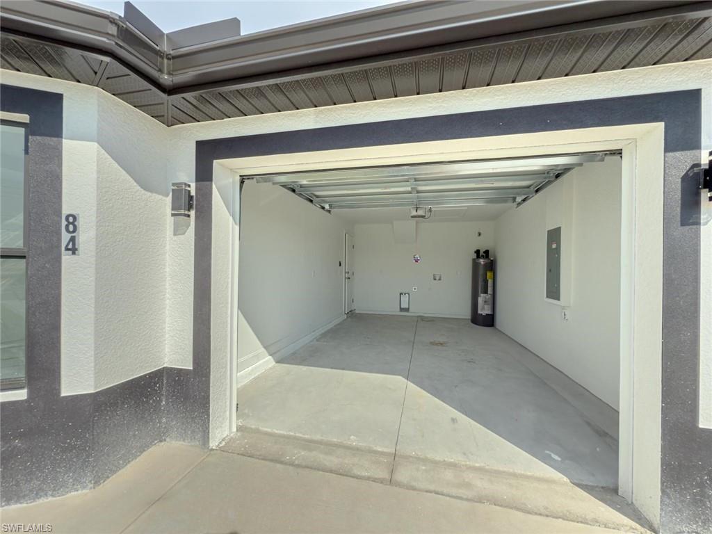 Garage featuring electric panel and water heater