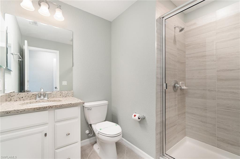 Bathroom featuring vanity, a shower stall, and light tile patterned floors