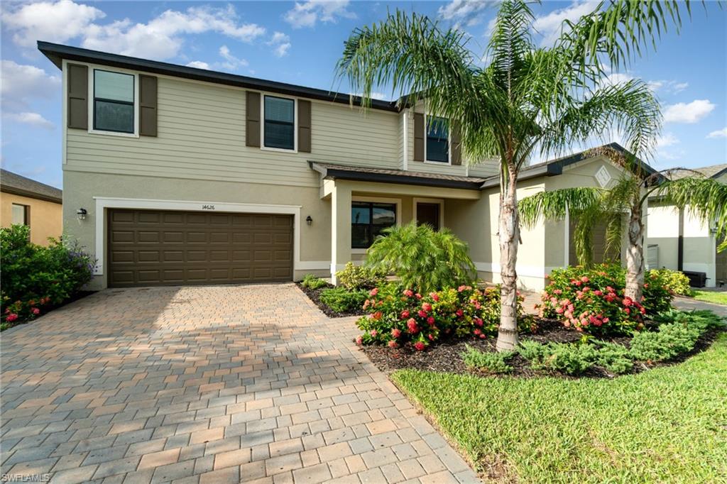 View of front of home featuring decorative driveway, an attached garage, and stucco siding