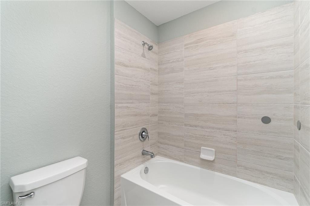 Full bathroom featuring shower / washtub combination and a textured wall