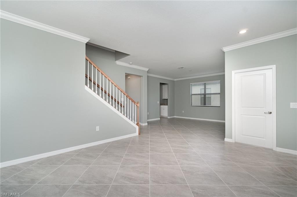Unfurnished room with ornamental molding, light tile patterned flooring, stairway, and recessed lighting