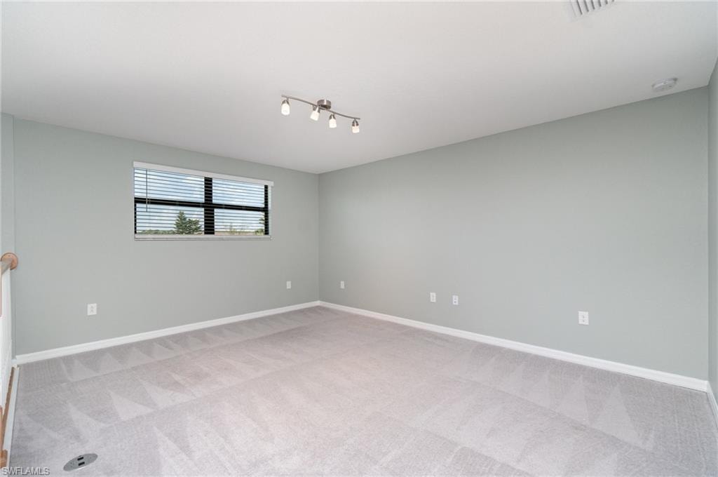 Unfurnished room with light colored carpet and baseboards