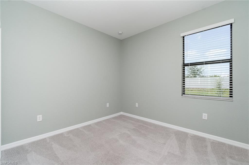 Unfurnished room featuring light colored carpet and baseboards