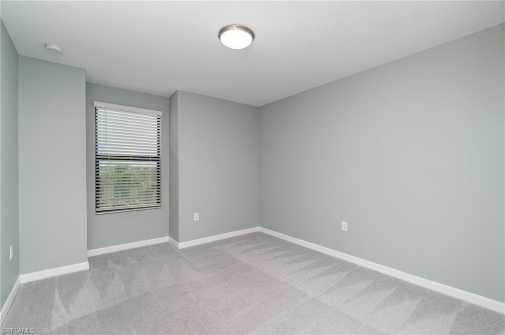 Spare room with light colored carpet and baseboards