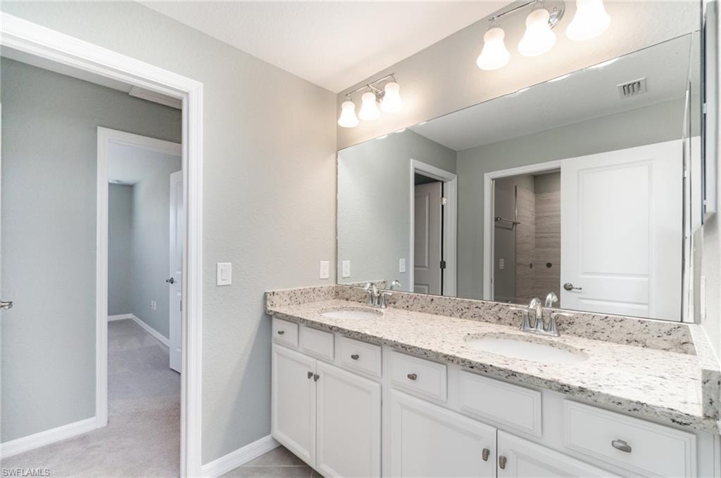 Bathroom featuring baseboards and double vanity