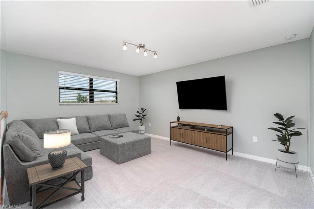 Carpeted living area with baseboards
