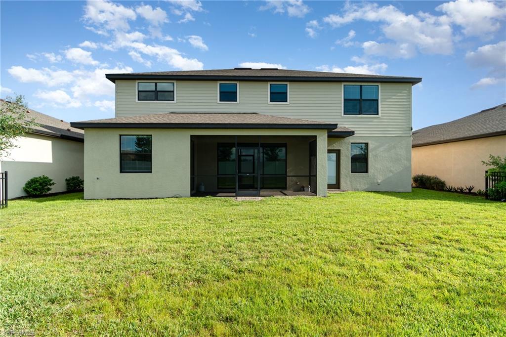 Rear view of house with a sunroom and stucco siding