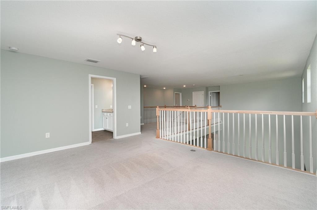 Spare room featuring carpet and baseboards