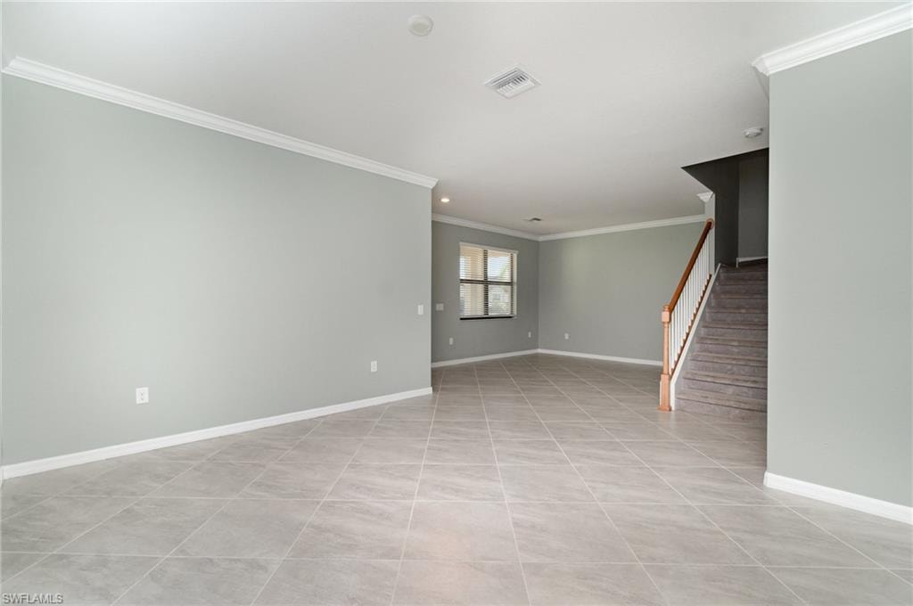 Empty room with ornamental molding, stairs, light tile patterned flooring, and recessed lighting