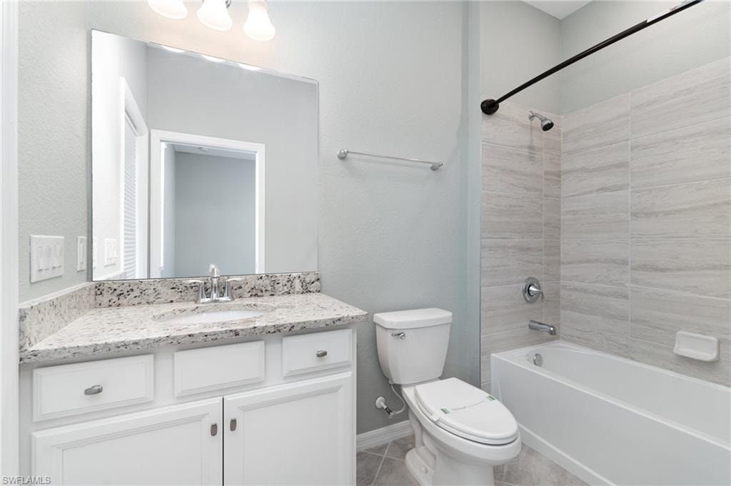Full bathroom with shower / bath combination, vanity, and light tile patterned floors