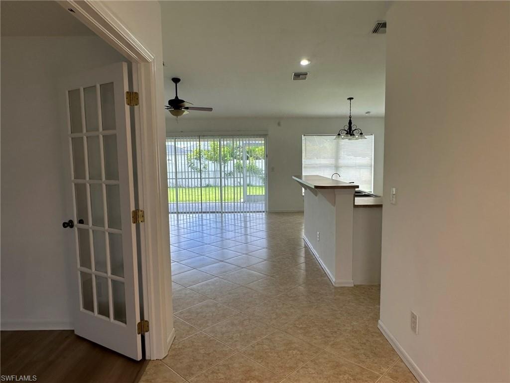 Hall with light tile patterned floors and recessed lighting