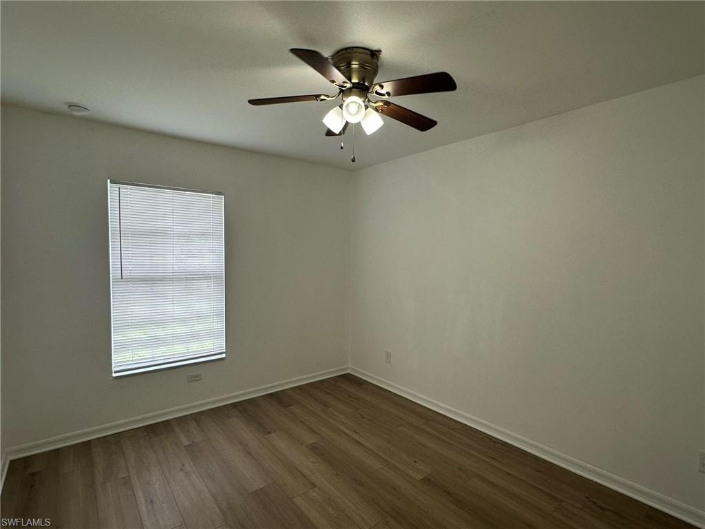 Unfurnished room with dark wood-type flooring and a ceiling fan