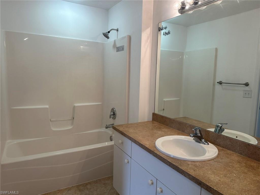 Bathroom featuring shower / bath combination, vanity, and light tile patterned floors