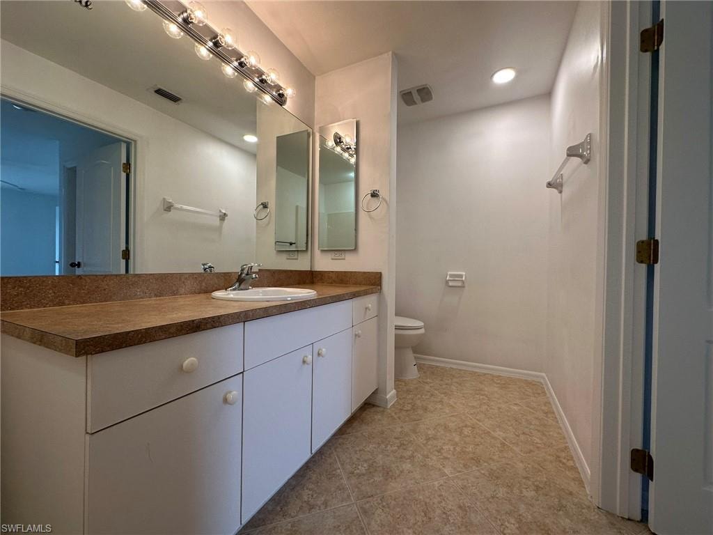 Bathroom featuring vanity, light tile patterned floors, and recessed lighting