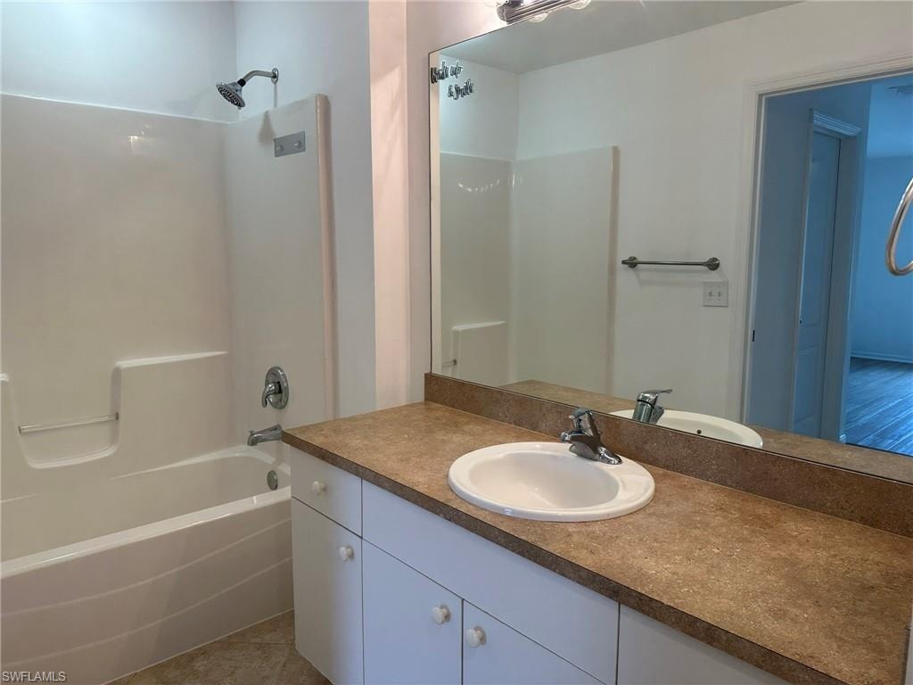 Full bathroom with shower / washtub combination, vanity, and light tile patterned flooring