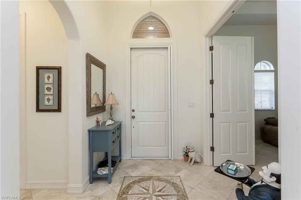 Travertine tile throughout with custom terrazzo insert in foyer
