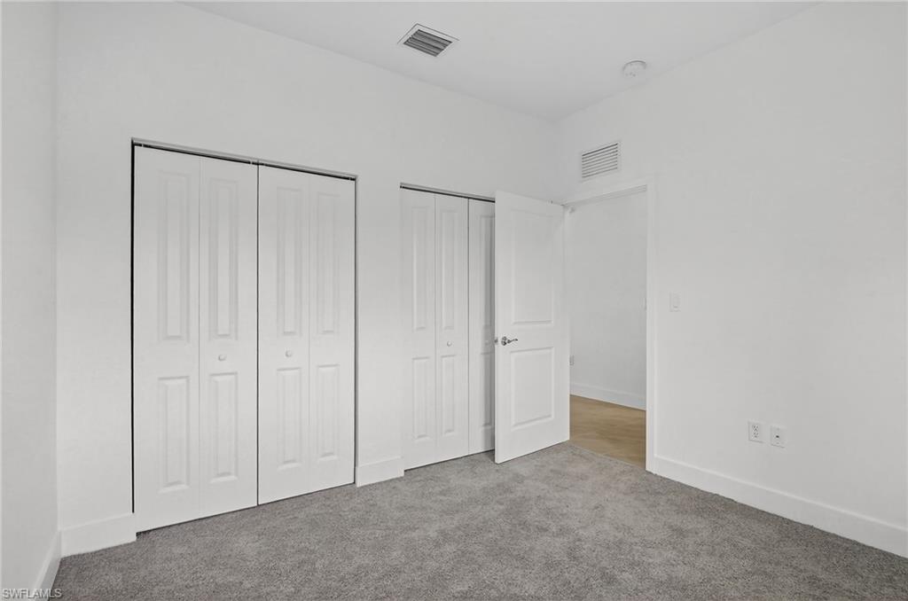 Unfurnished bedroom with multiple closets and carpet flooring