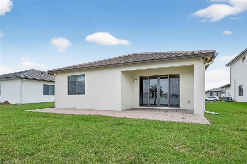 Back of property featuring stucco siding, a yard, and a patio