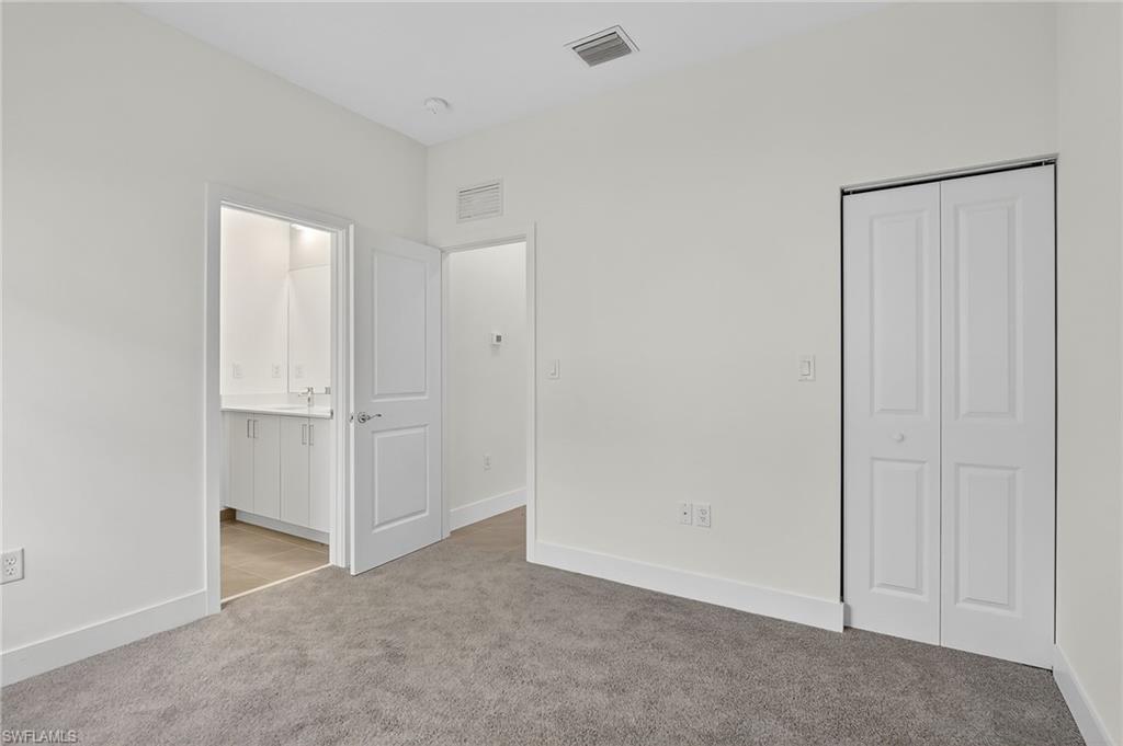 Unfurnished bedroom featuring light carpet and a closet
