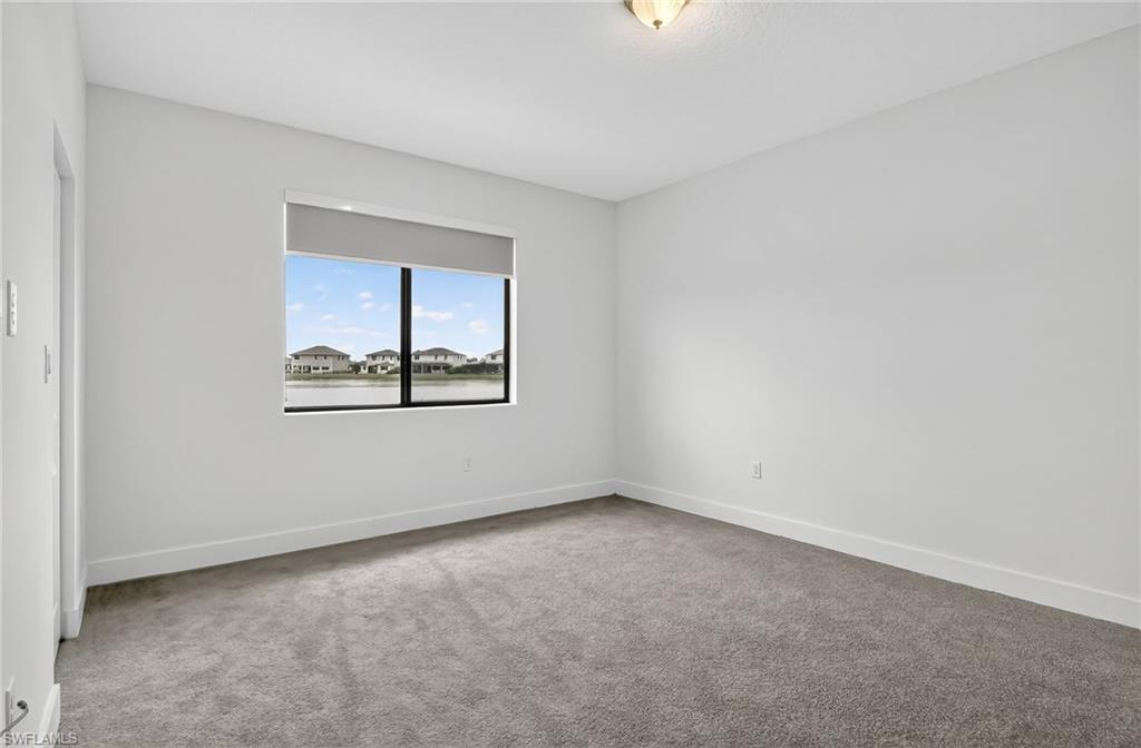 Unfurnished room featuring light colored carpet and baseboards