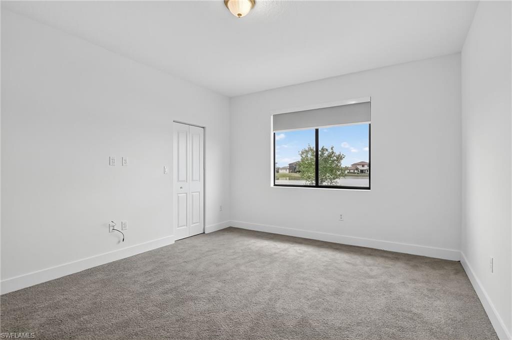 Unfurnished room featuring light colored carpet and baseboards
