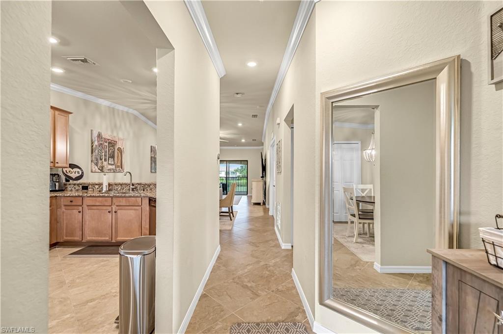 Entry hall featuring ornamental molding, a textured wall, and recessed lighting