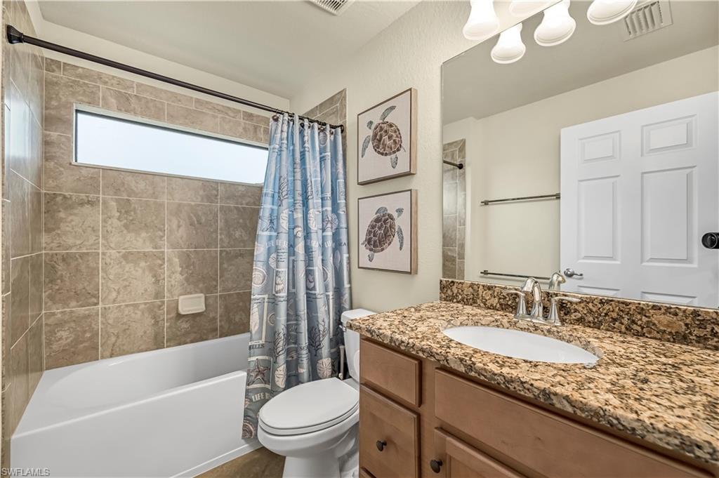 Full bathroom featuring shower / bathtub combination with curtain and vanity