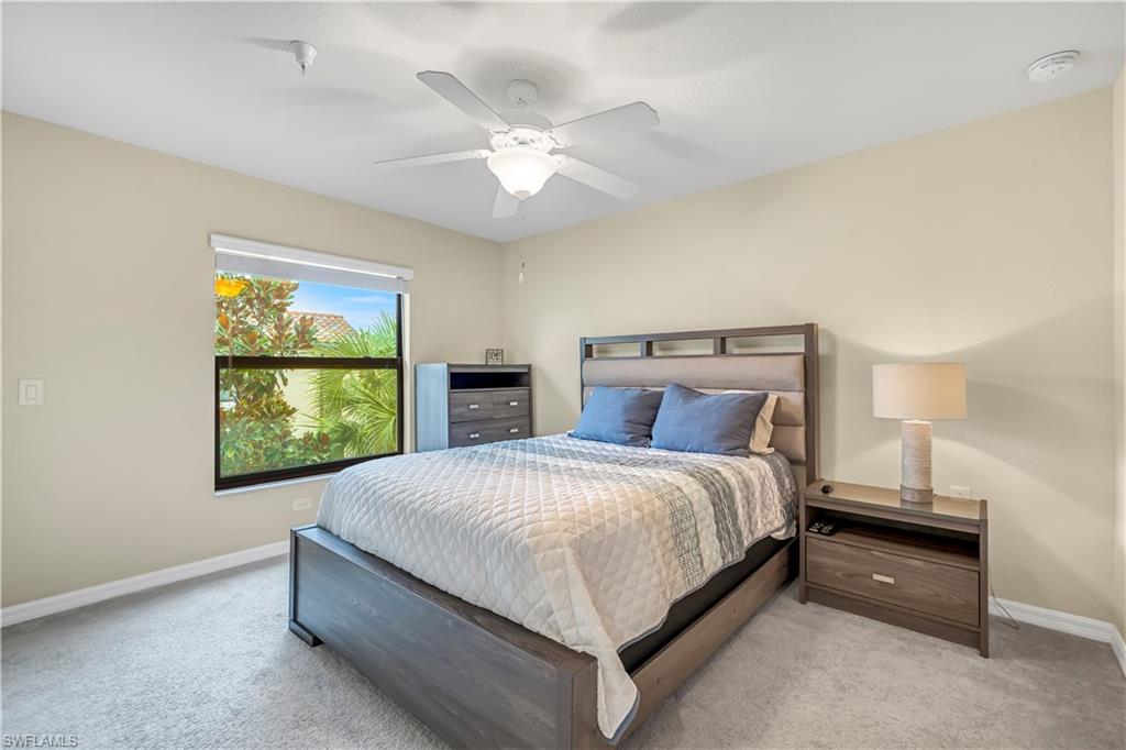 Carpeted bedroom featuring baseboards and ceiling fan