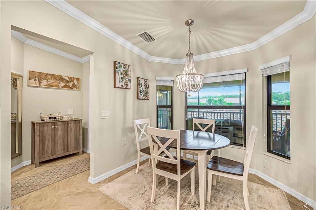 Dining room featuring ornamental molding, light tile patterned floors, and a chandelier