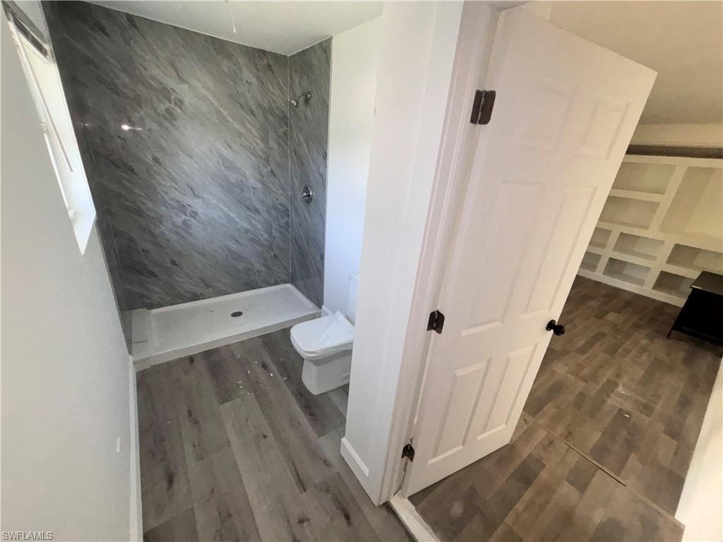 Bathroom featuring a stall shower and dark wood finished floors