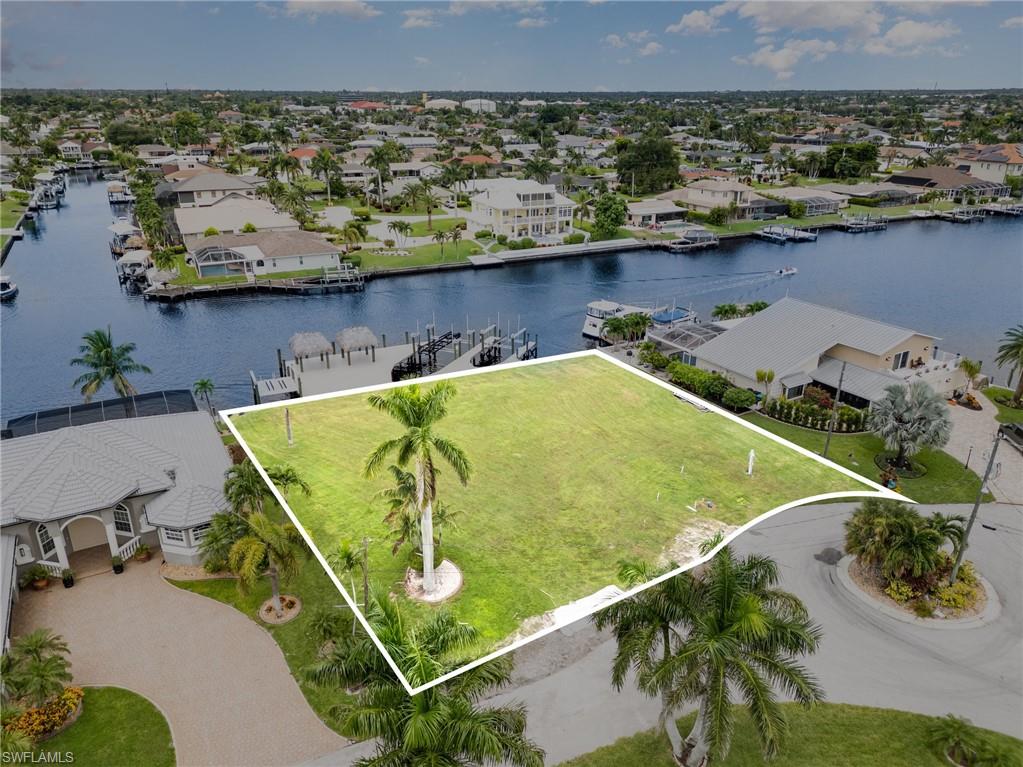 Aerial perspective of suburban area featuring property parcel outlined and a nearby body of water