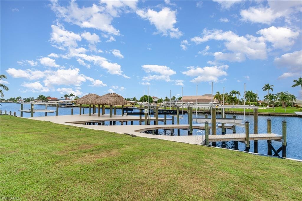 Dock area featuring a lawn, a water view, and boat lift