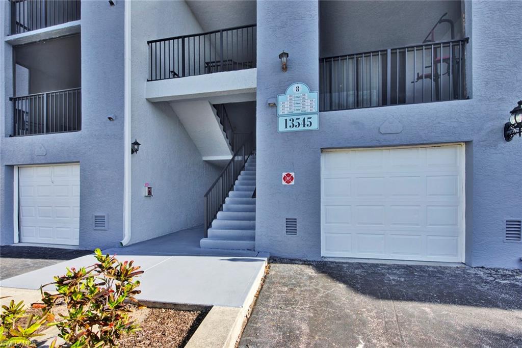 View of property featuring stairs and a garage