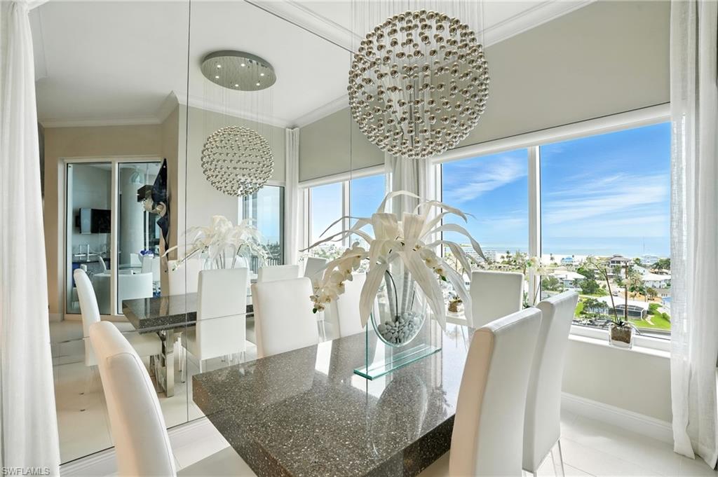 Dining area with ornamental molding, plenty of natural light, light tile patterned flooring, and a chandelier - Virtually Edited Image